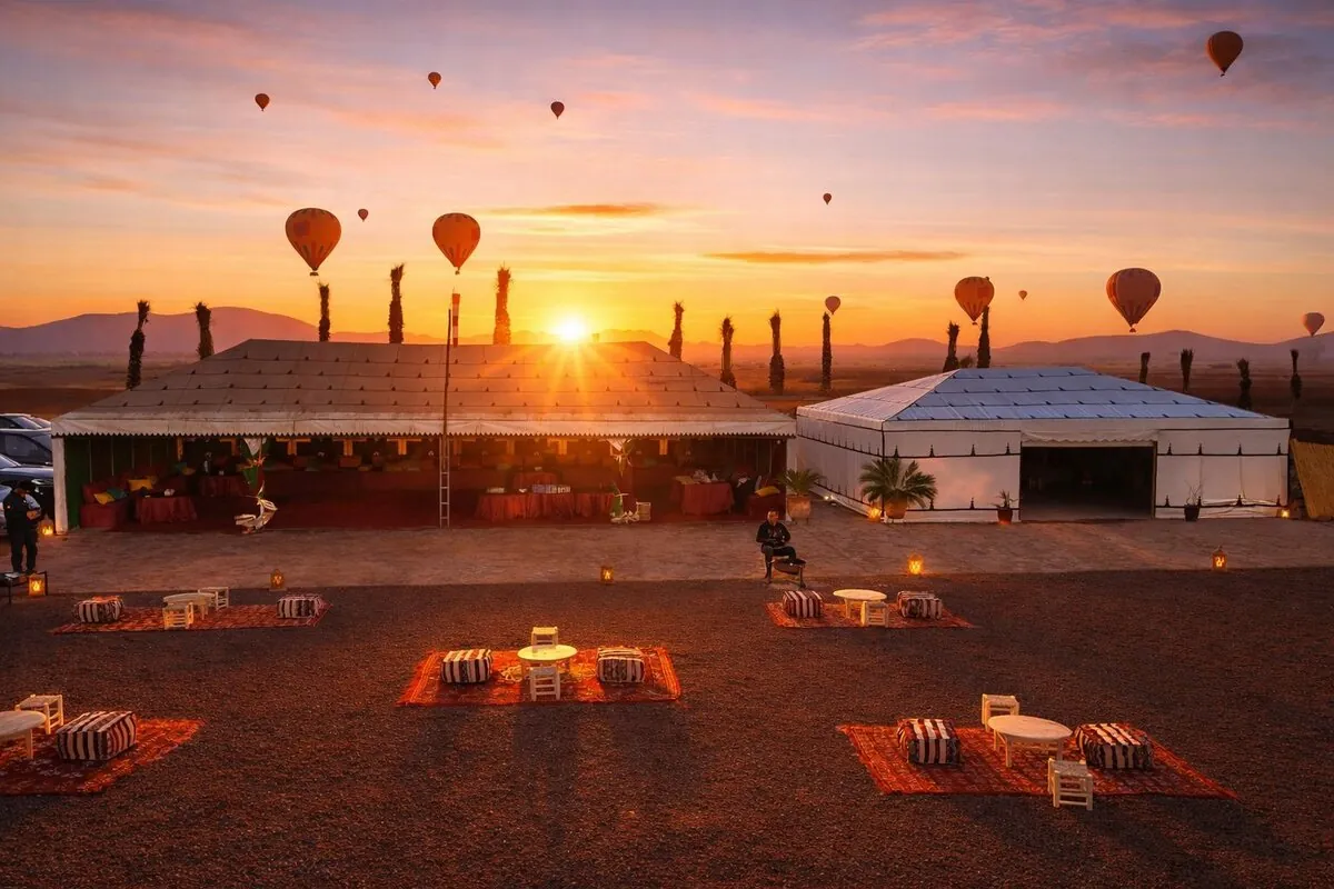 VIP breakfast camp with hot air balloons in sky at sunset near Marrakech